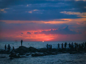 Sunset over the rugged coastline of Chubut with a small group of hikers admiring the view.