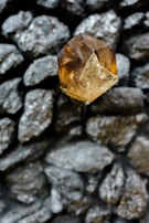 a yellow diamond sitting on top of a pile of rocks