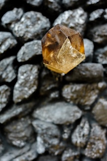 a yellow diamond sitting on top of a pile of rocks