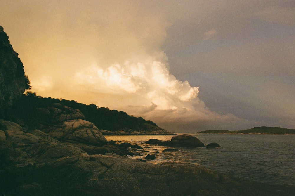 a large body of water sitting next to a rocky shore