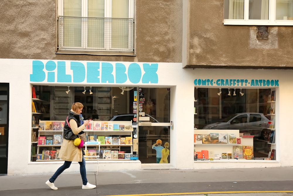 a woman walking down the street in front of a store