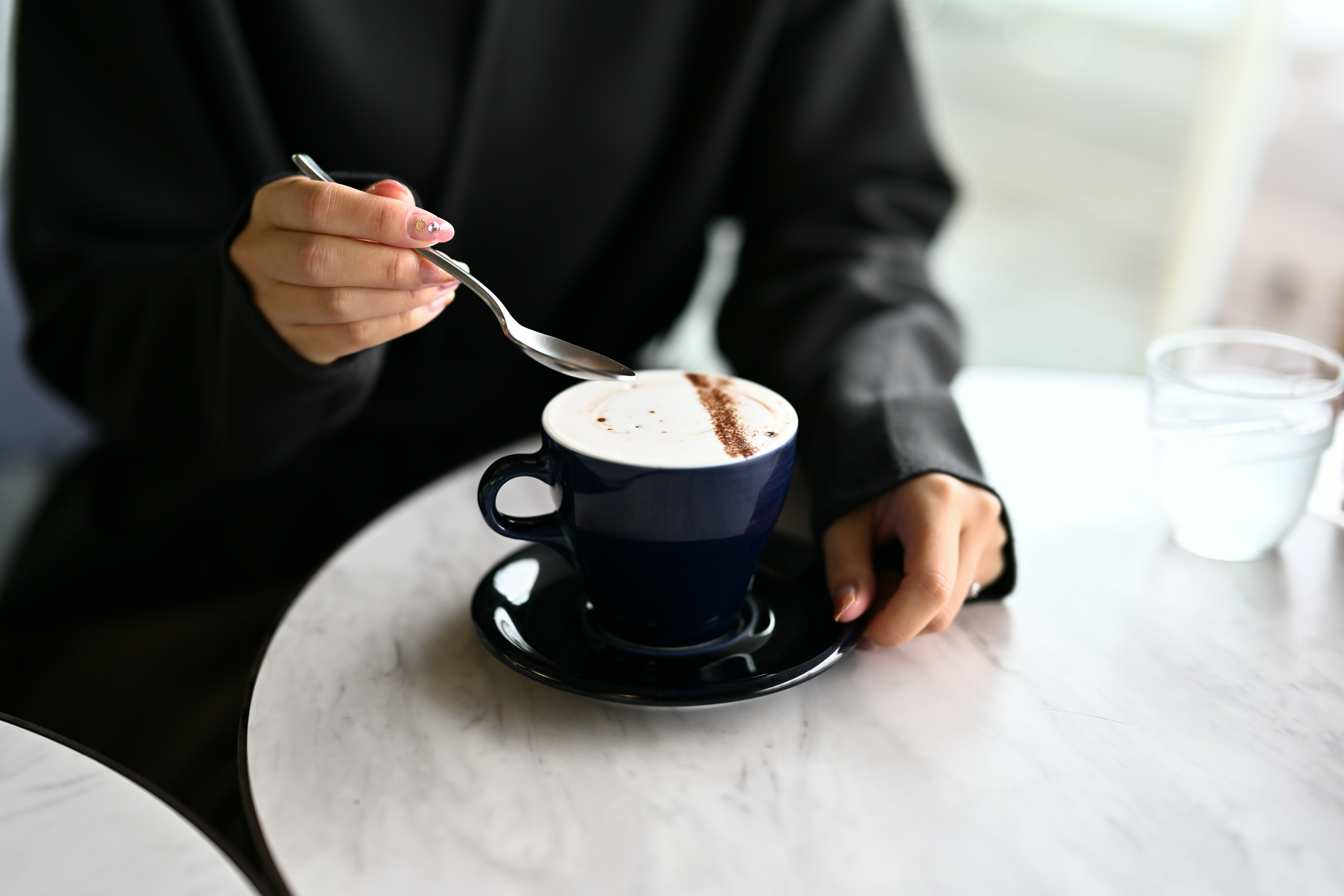 a person sitting at a table with a cup of coffee