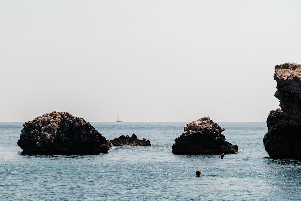 a couple of rocks in the middle of a body of water