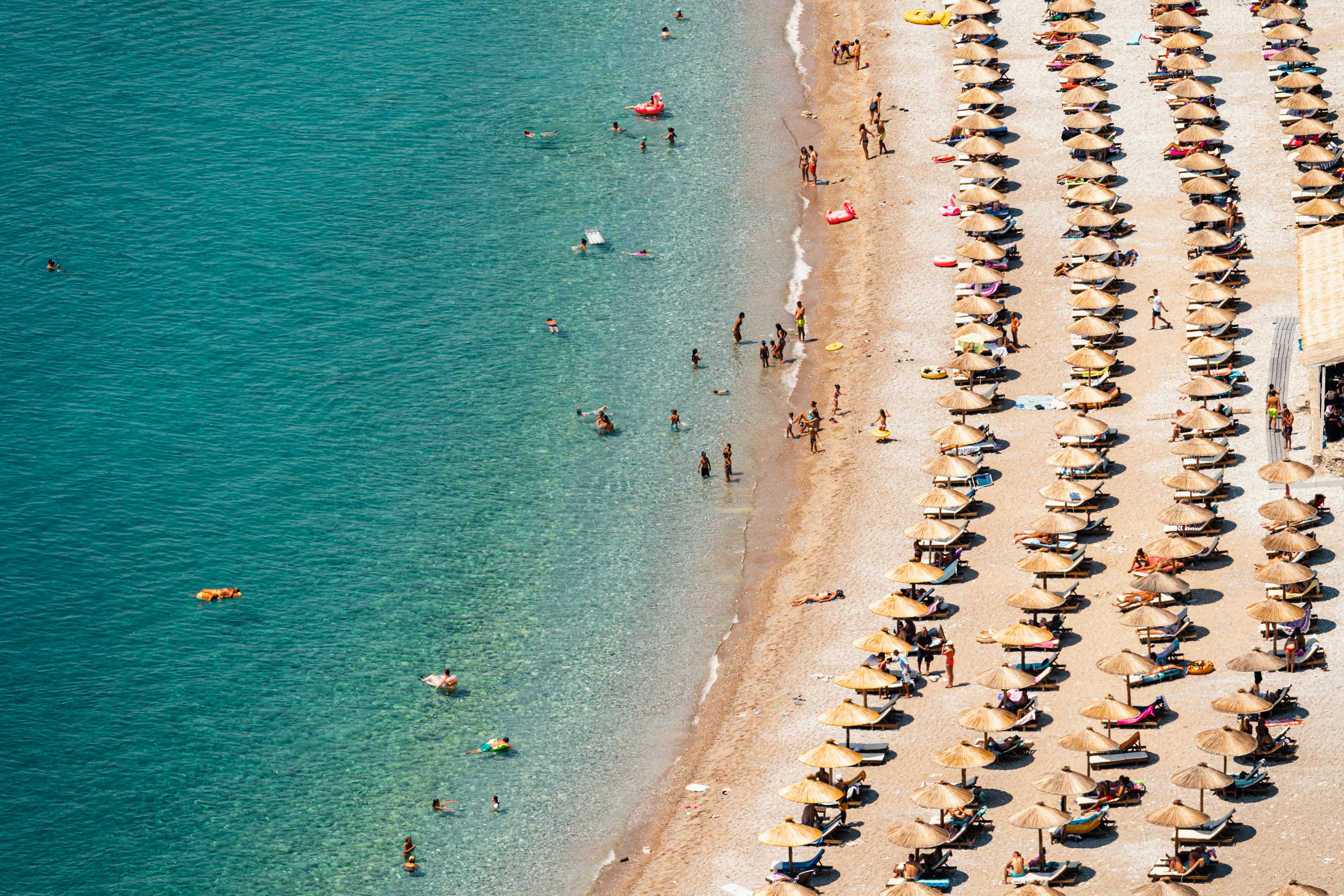 a group of people standing on top of a sandy beach