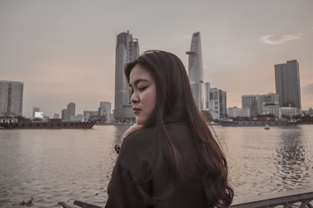 a woman standing next to a body of water