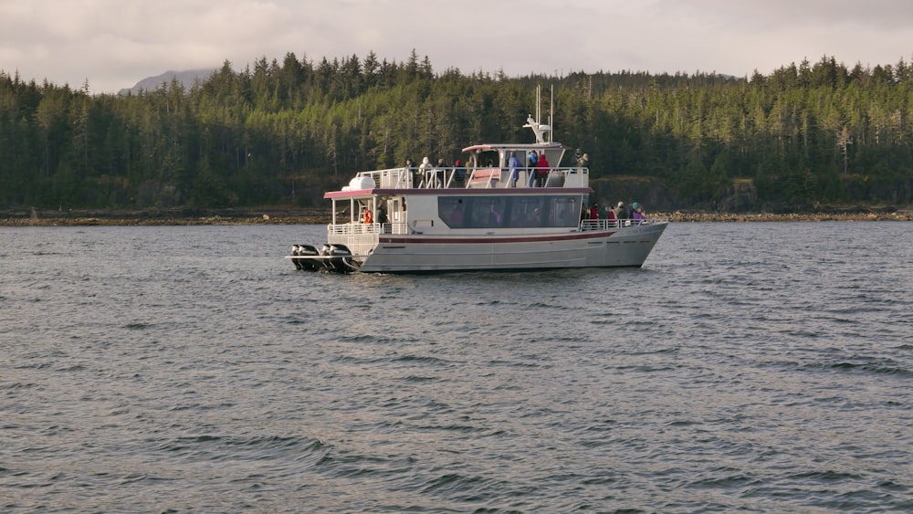 a white boat with people on it in a body of water