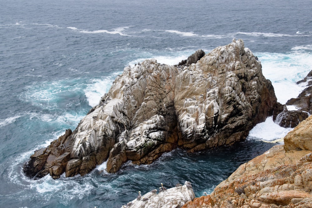 Ein großer Felsen, der aus dem Ozean ragt