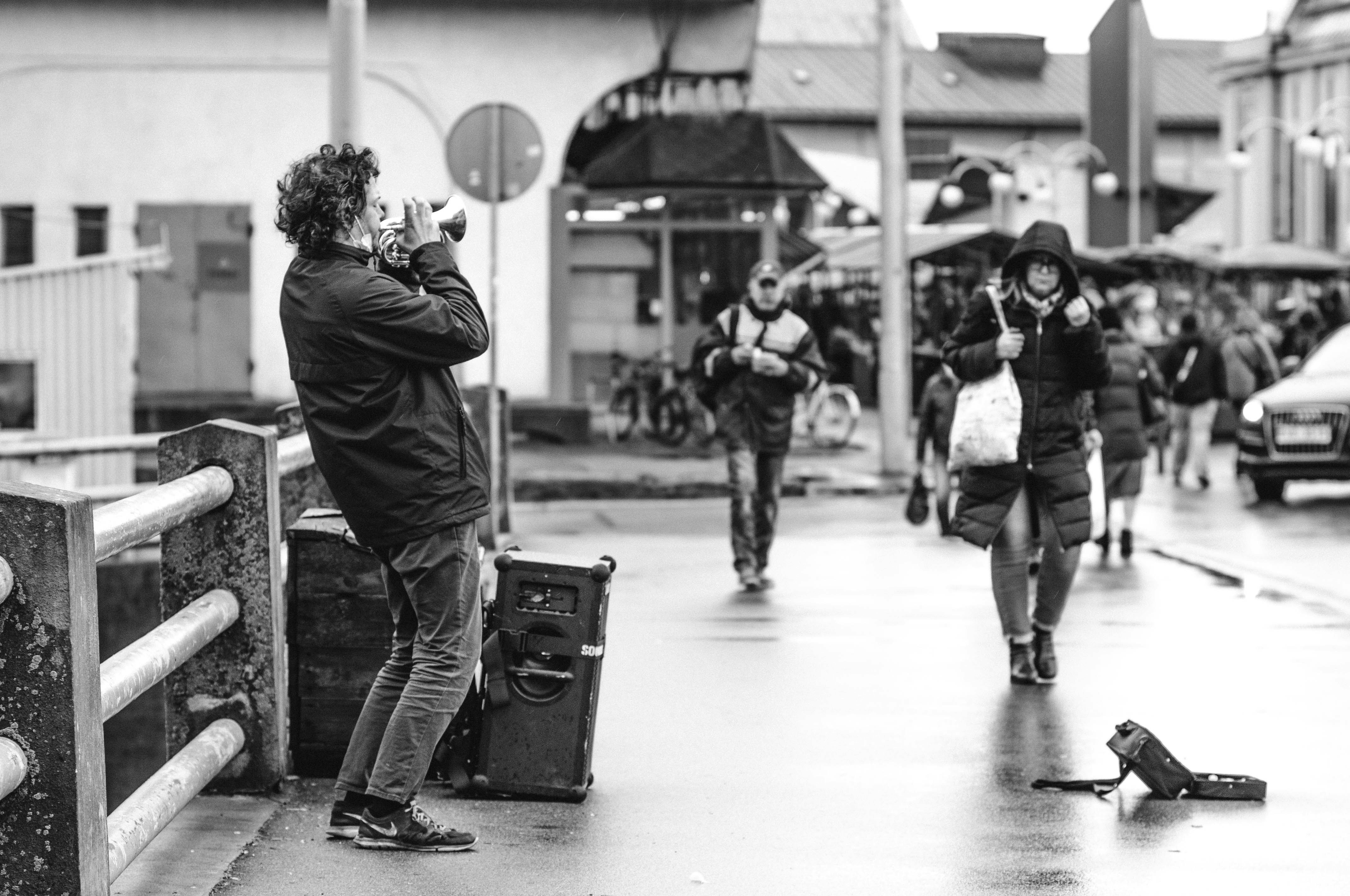 Fotógrafo usando objetiva de distância focal longa com distância de trabalho ampla em rua urbana