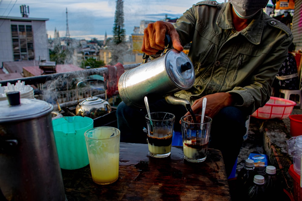 a man pouring a drink into a cup