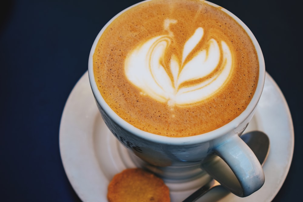 a cup of cappuccino on a saucer with a spoon