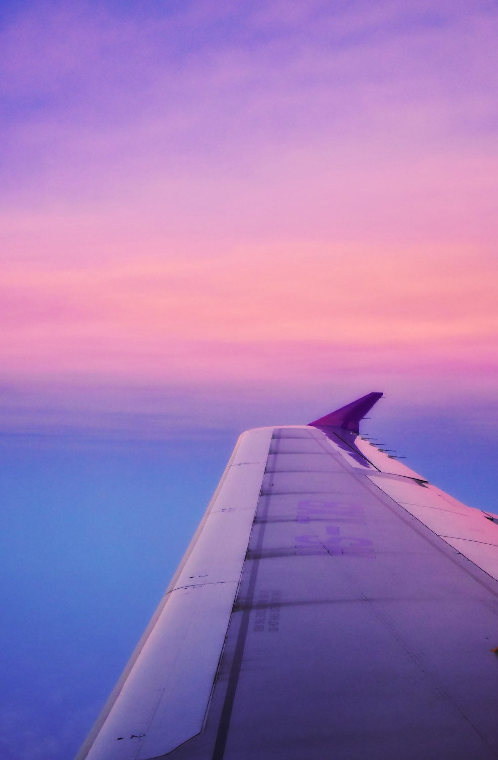 the wing of an airplane as the sun sets