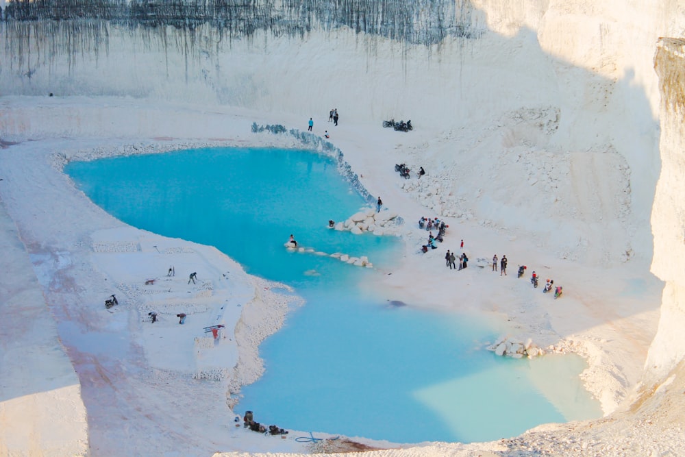 a group of people standing around a pool of water