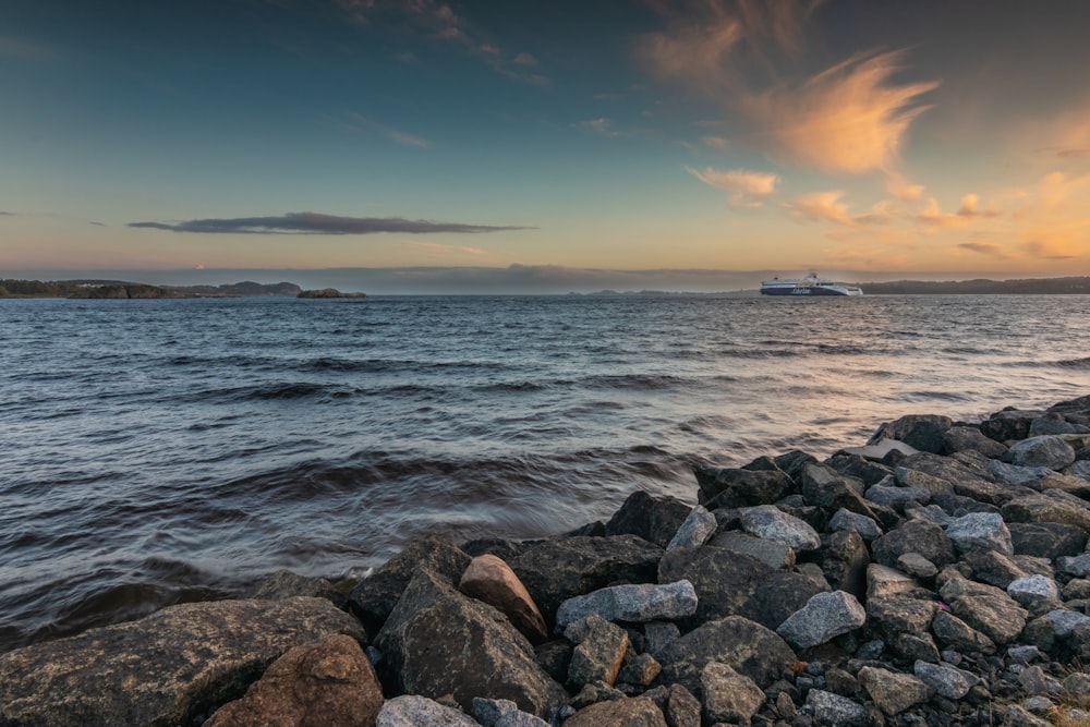 a large body of water sitting next to a rocky shore