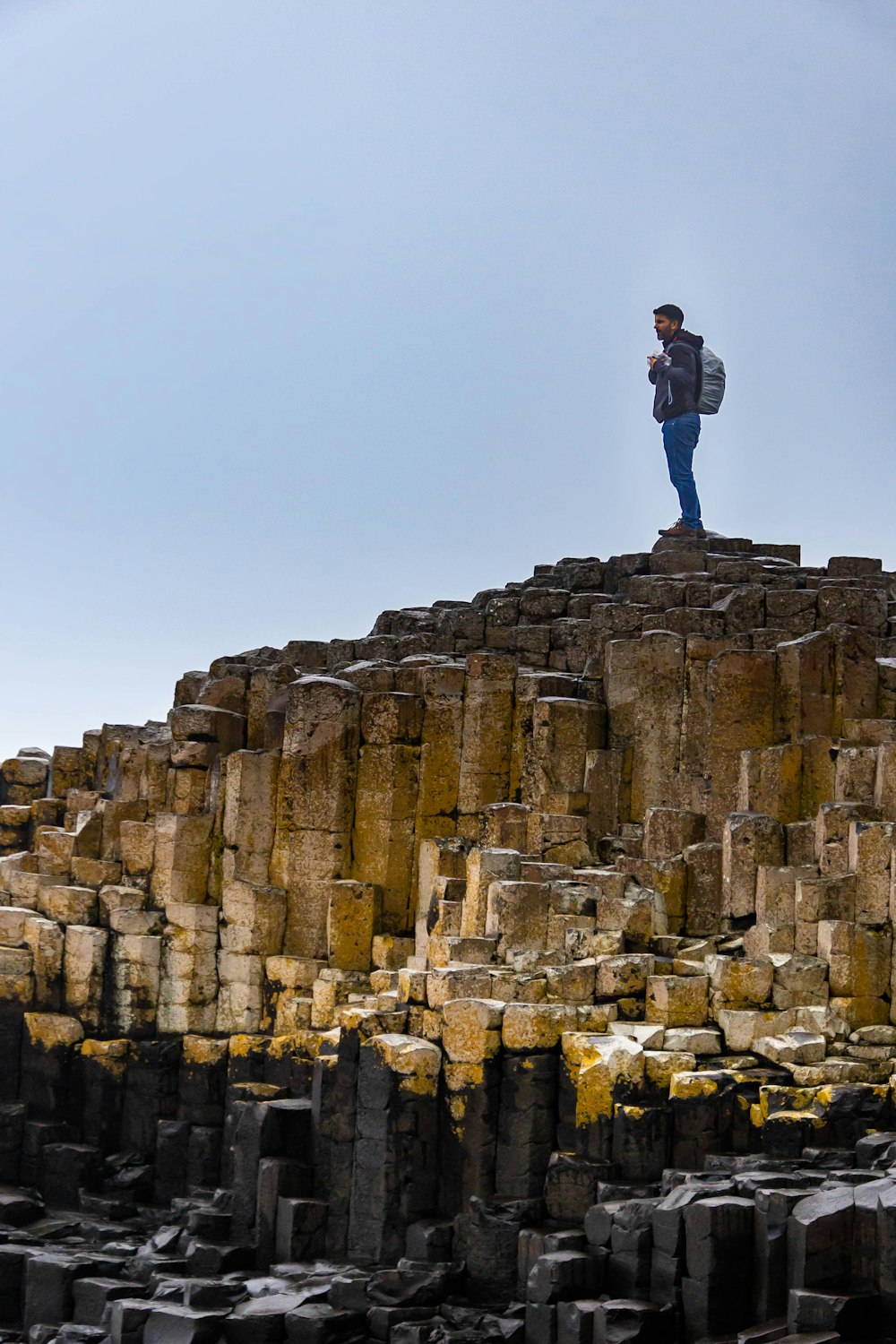 a man standing on top of a large rock formation