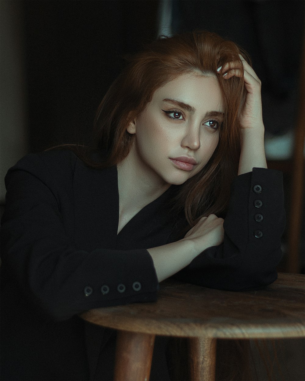 a woman sitting at a table with her hand on her head