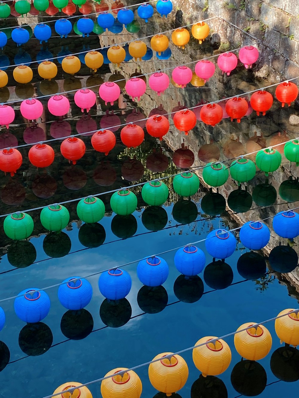 una fila di vasi colorati seduti sopra uno specchio d'acqua