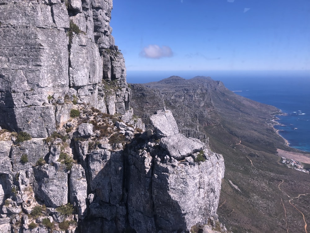 a view of a rocky cliff with a body of water in the distance