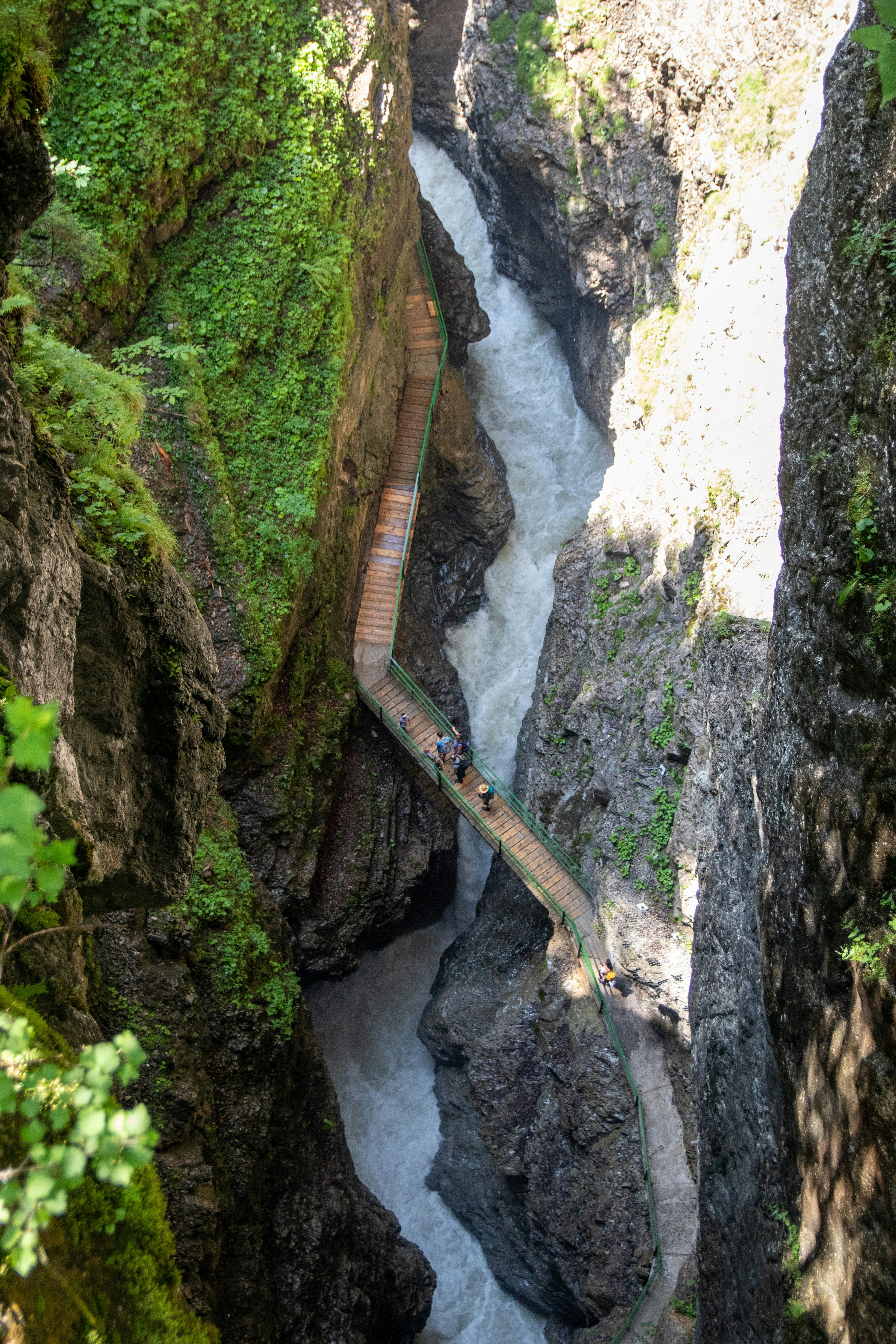 Un largo puente de madera sobre un río en un cañón