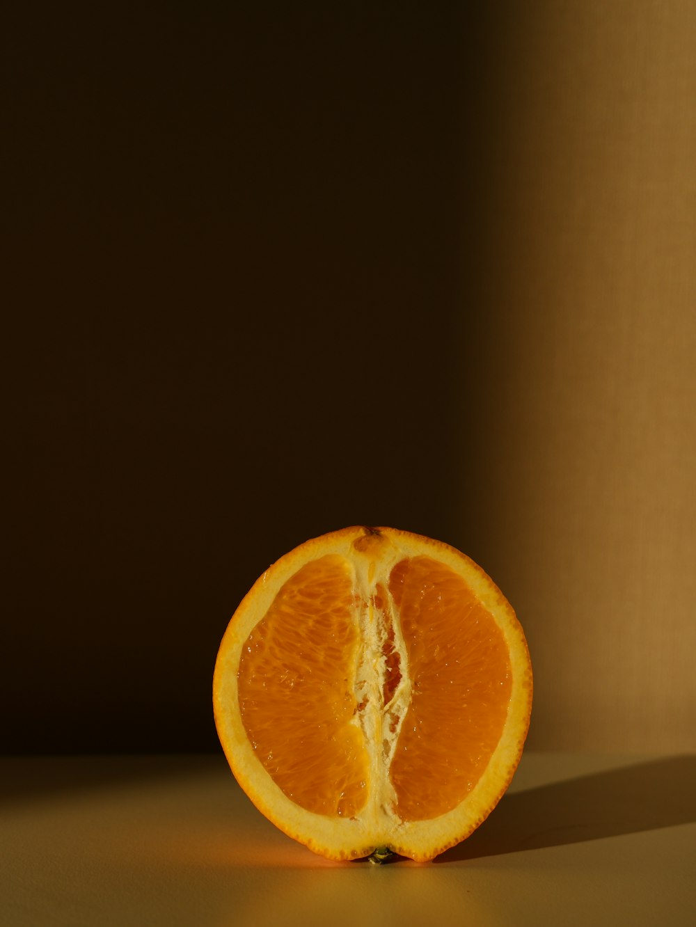 an orange cut in half sitting on a table