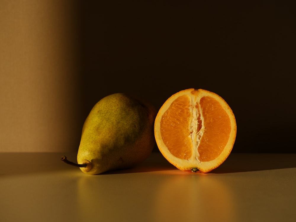 an orange and a pear on a table