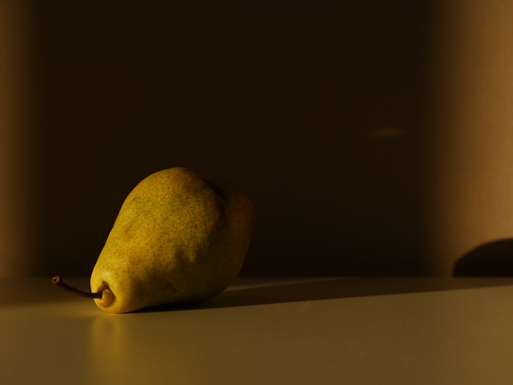 a yellow pear sitting on top of a table