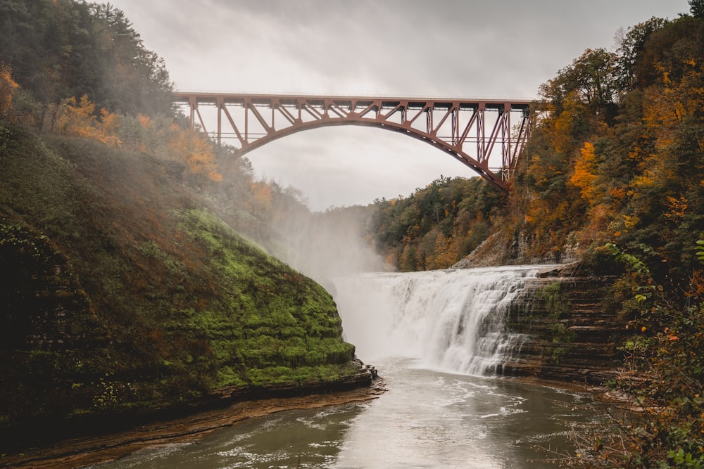 uma ponte sobre um rio com uma cachoeira abaixo