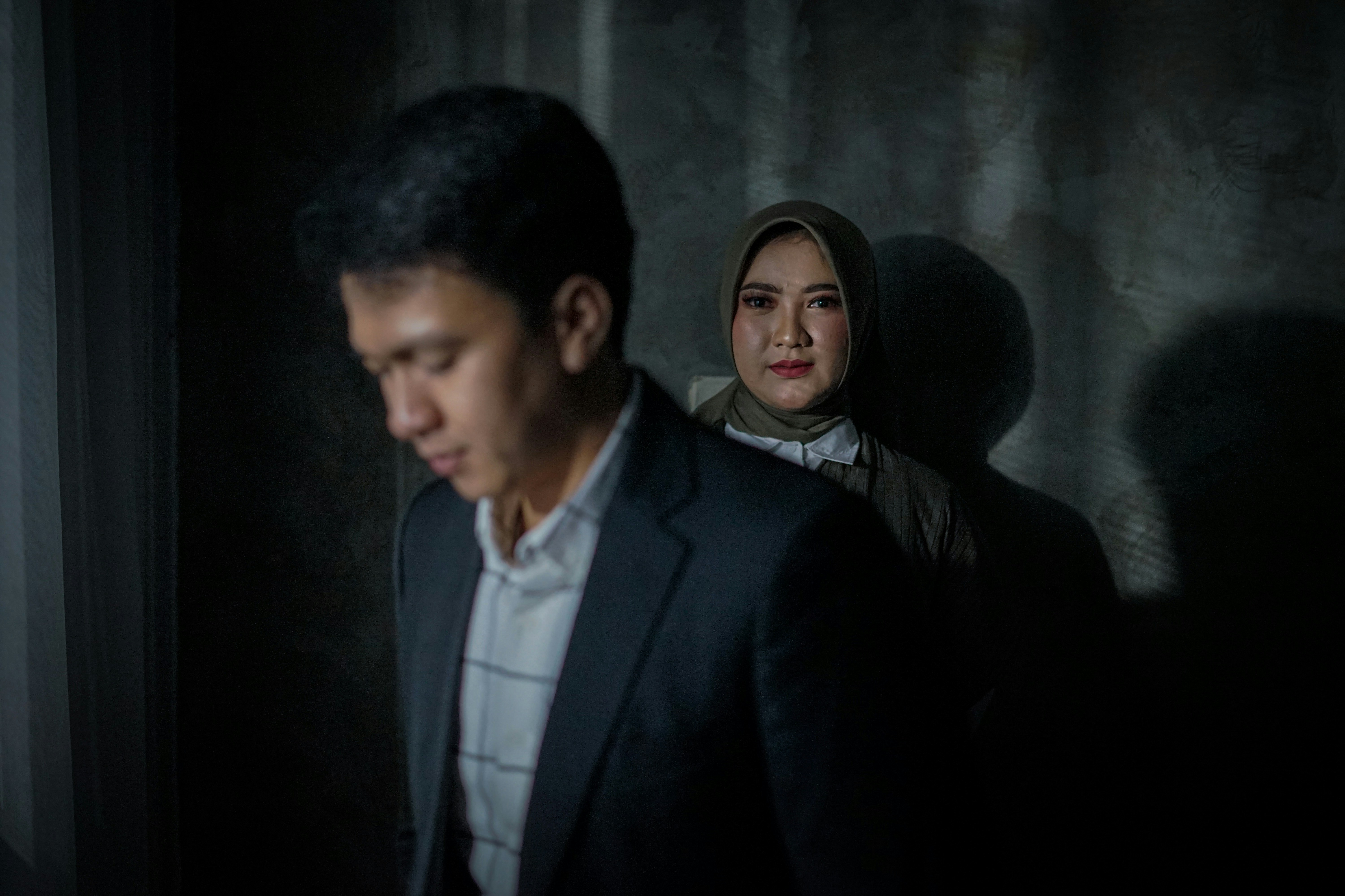 a man standing next to a woman in a dark room