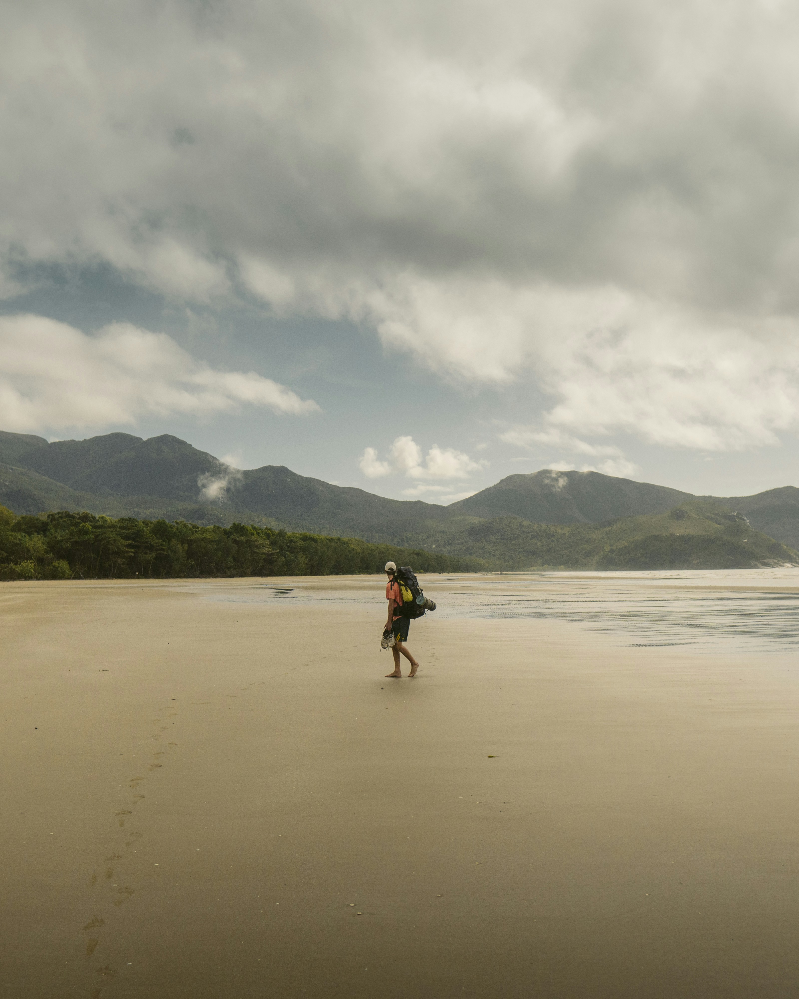 a person with a backpack walking on a beach