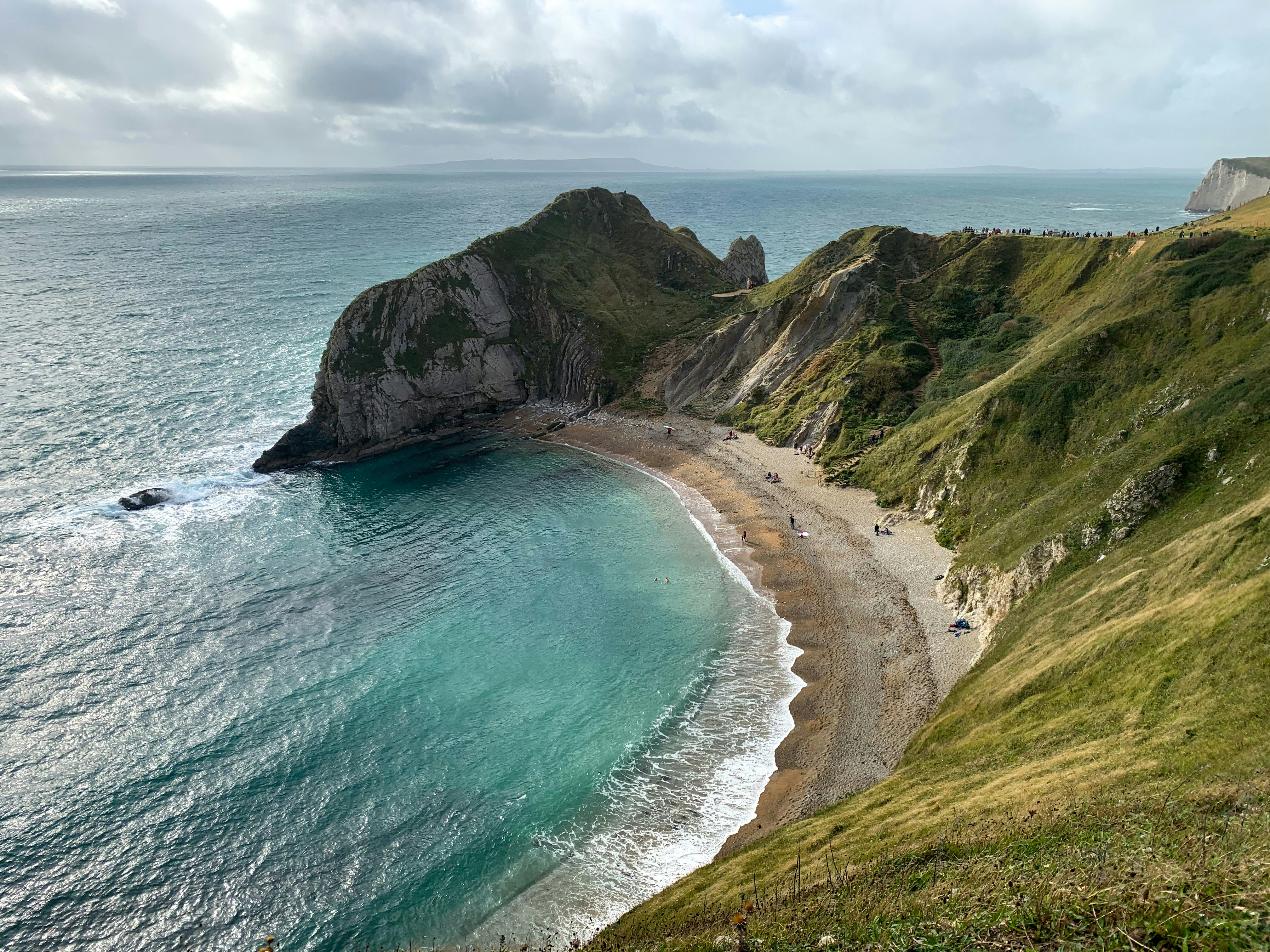 a view of a beach from a hill overlooking the ocean