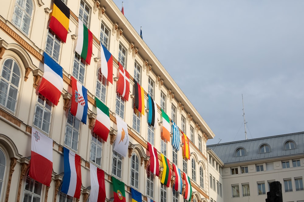 a building with a bunch of flags hanging from it's sides