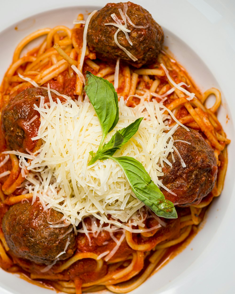 a white plate topped with spaghetti and meatballs