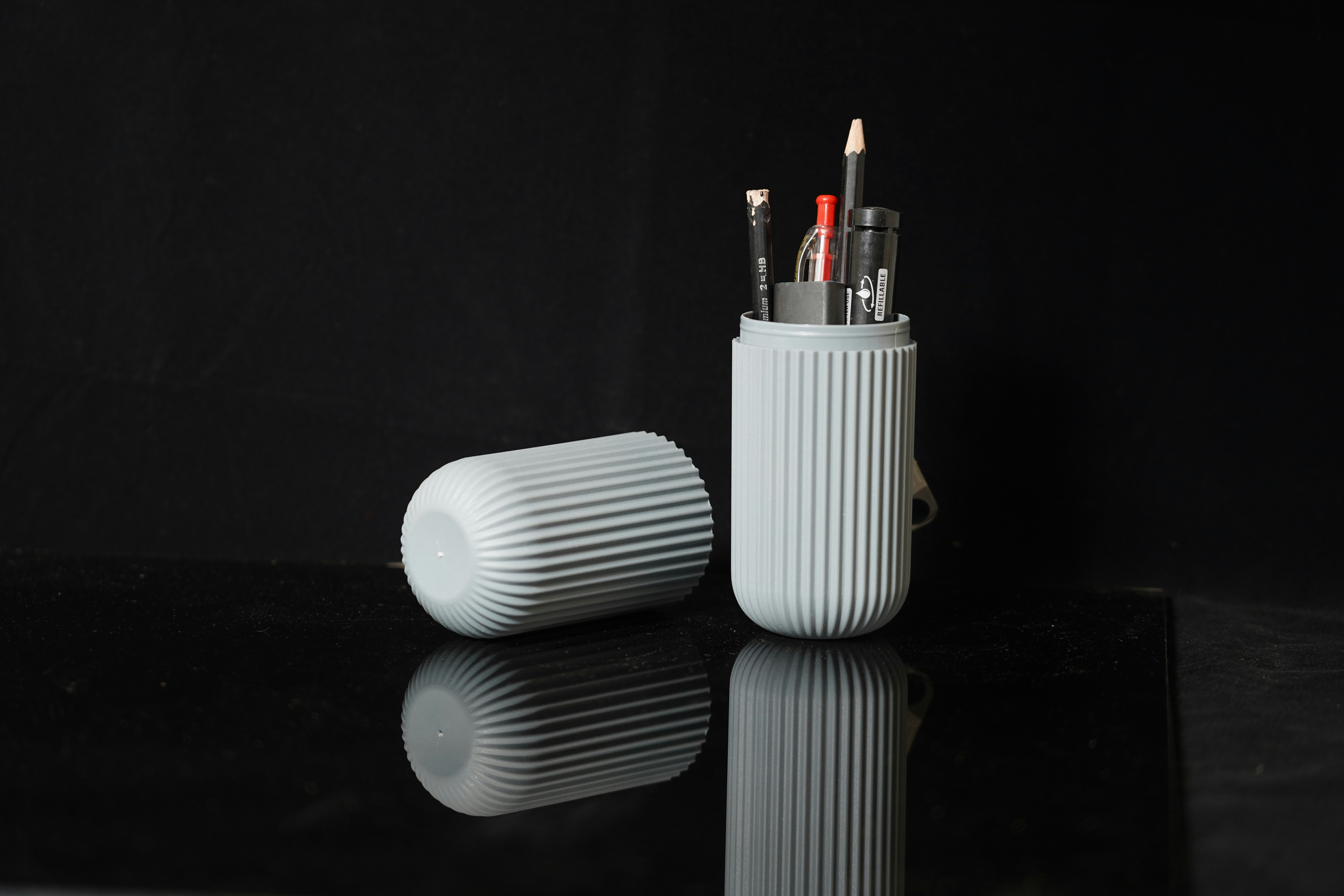 a couple of pens sitting in a cup on a table
