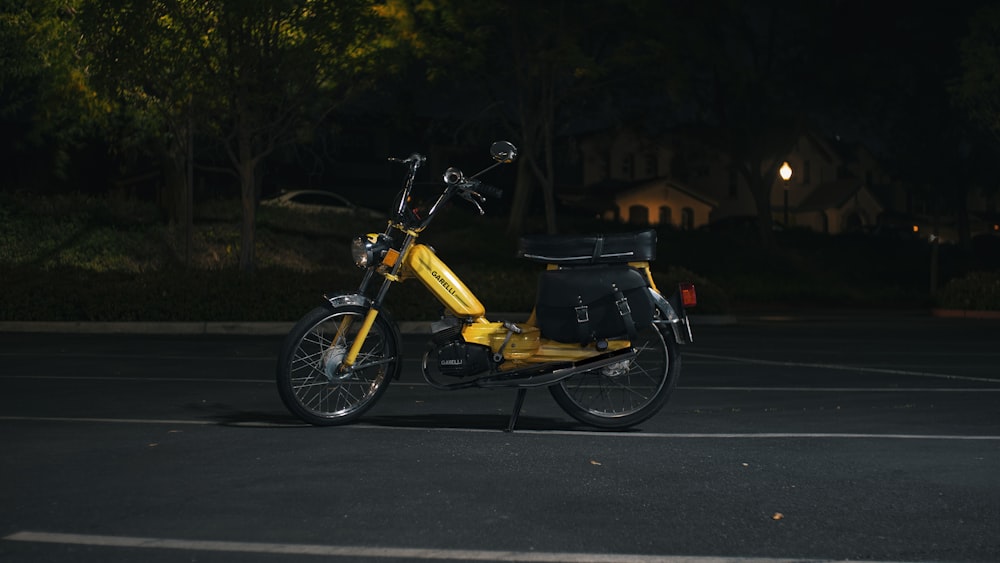 a yellow scooter parked in a parking lot at night