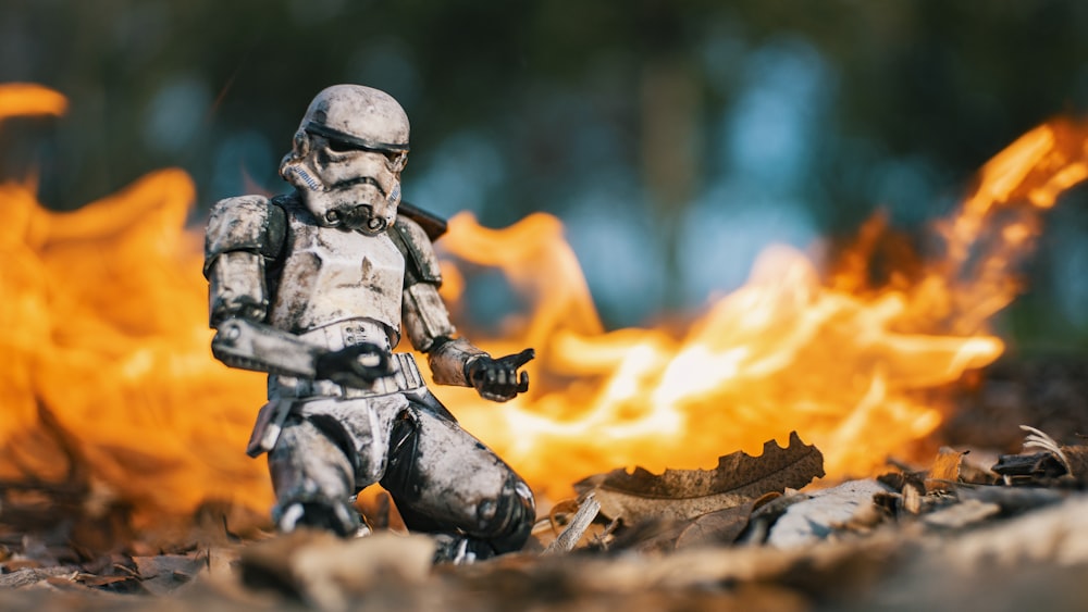 a star wars action figure standing in front of a fire