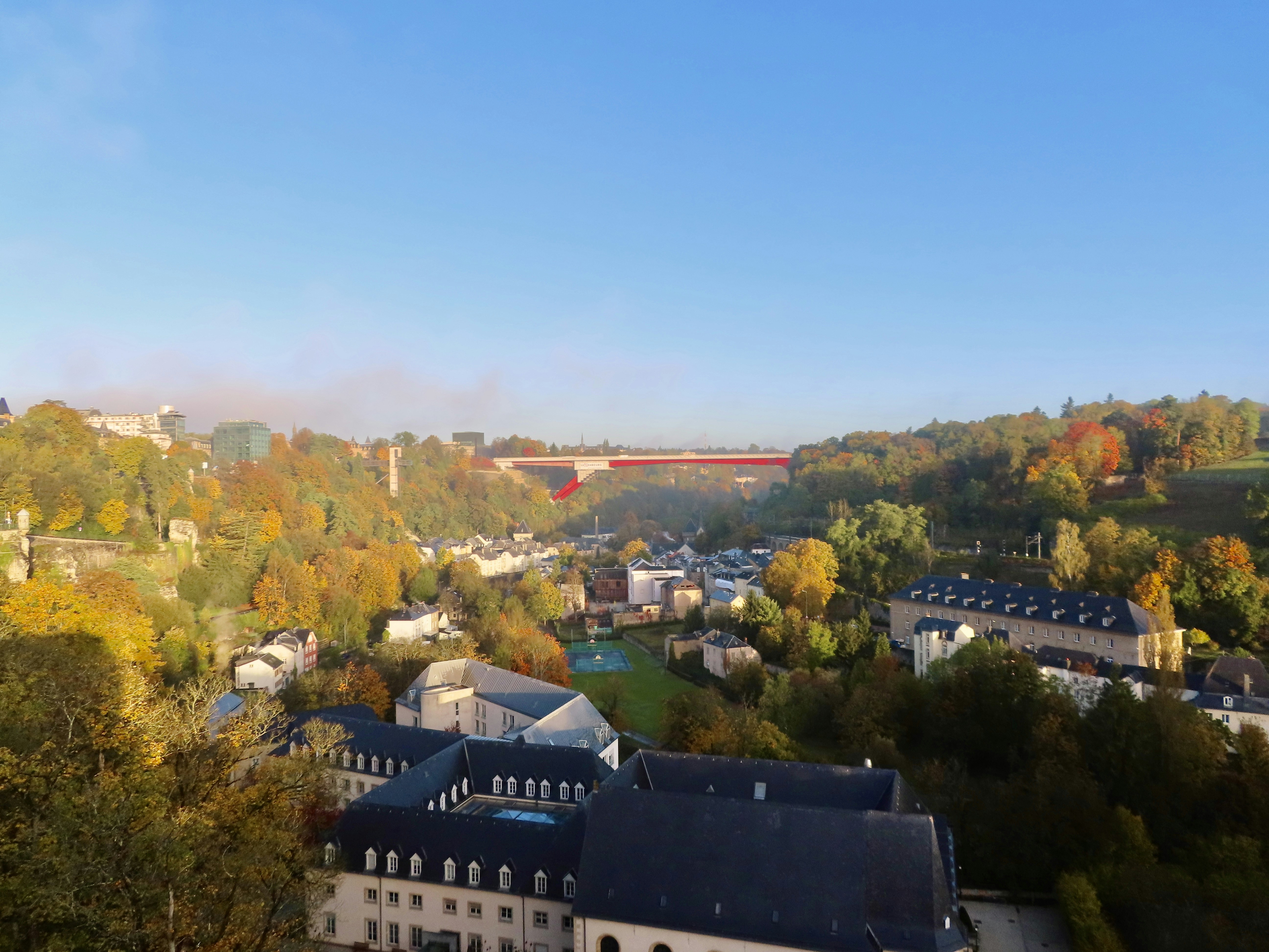 an aerial view of a city with a bridge in the background