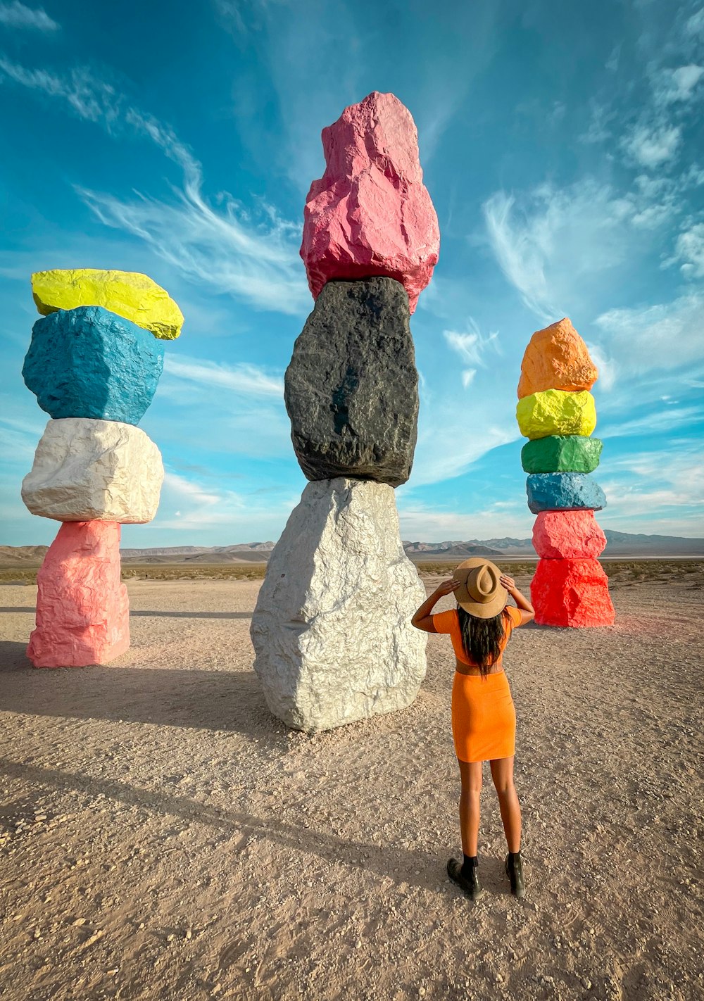 a woman standing in front of a stack of rocks