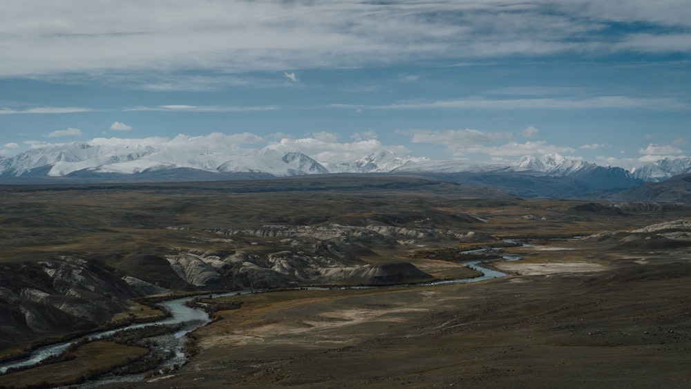 a river running through a valley surrounded by mountains