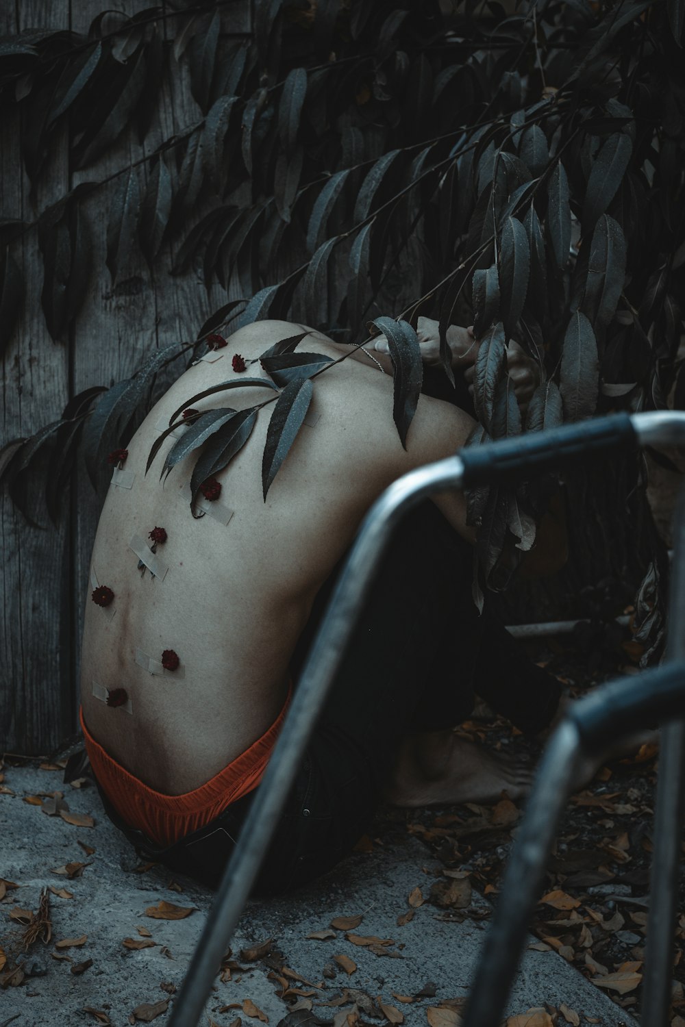 a man laying on the ground next to a fence