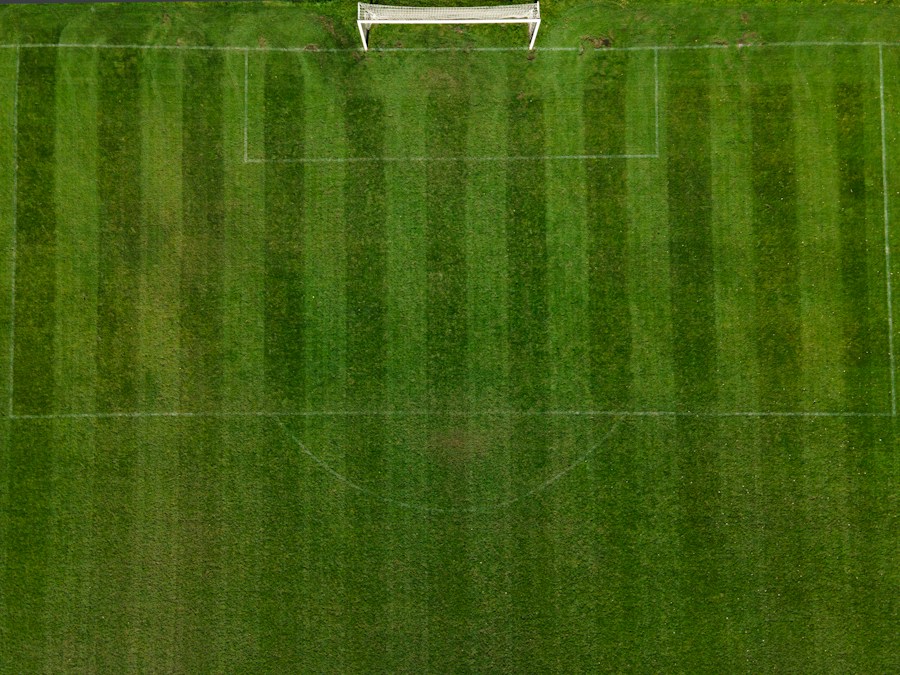 Vue aérienne d’un terrain de football et de son but, lignes blanches tracées sur la pelouse