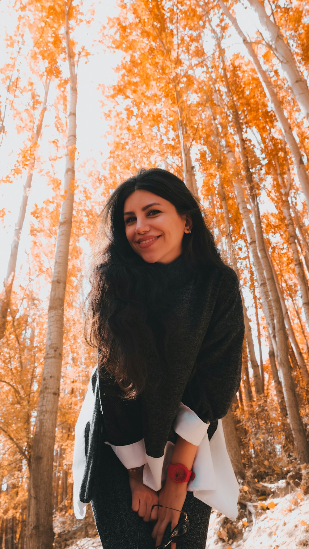 a woman standing in front of a grove of trees