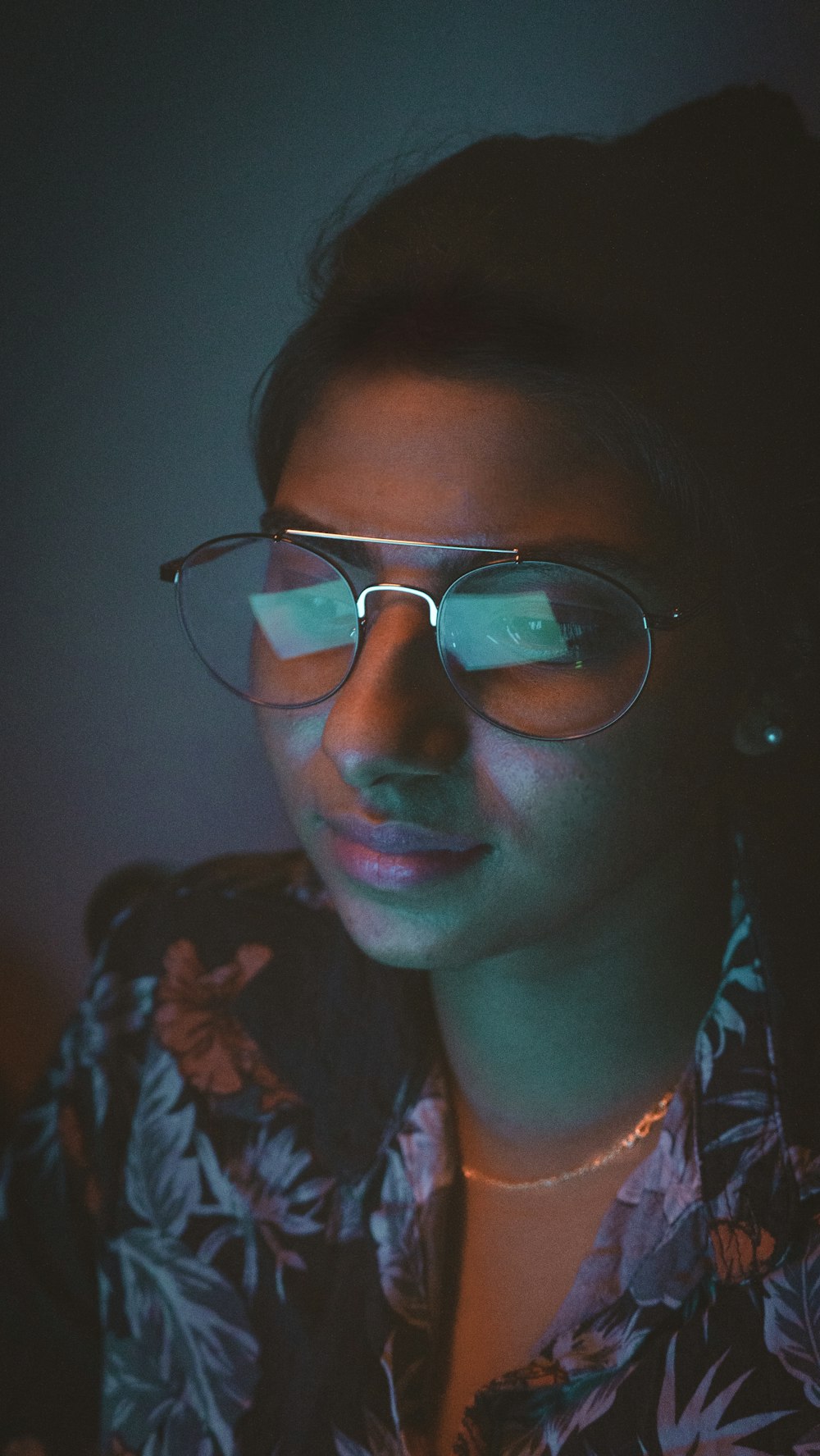 a woman wearing glasses in a dark room