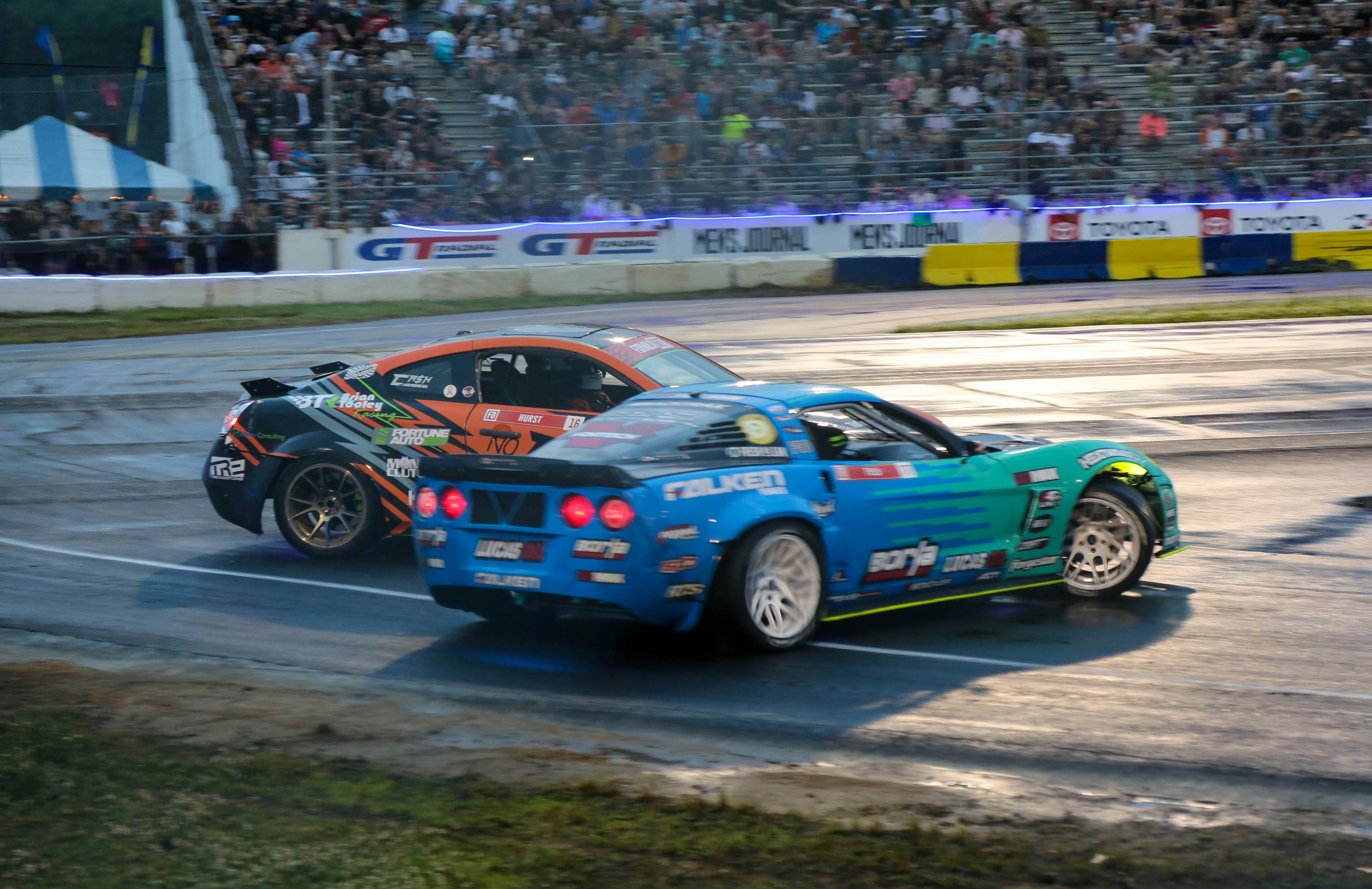 a couple of cars driving down a race track