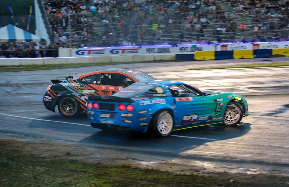 a couple of cars driving down a race track