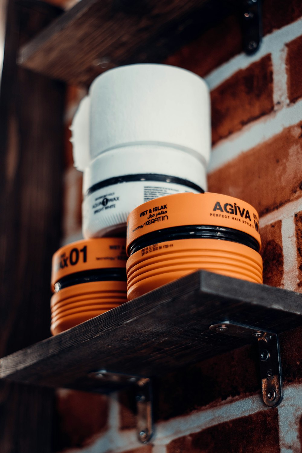 a couple of orange cups sitting on top of a shelf