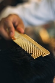 a close up of a person cutting a mans hair