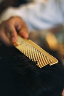 a close up of a person cutting a mans hair