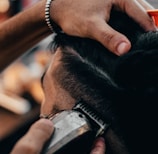 a close up of a person cutting another persons hair