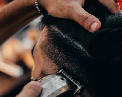 a close up of a person cutting another persons hair
