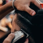 a close up of a person cutting another persons hair