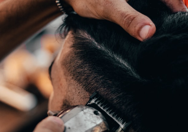 a close up of a person cutting another persons hair